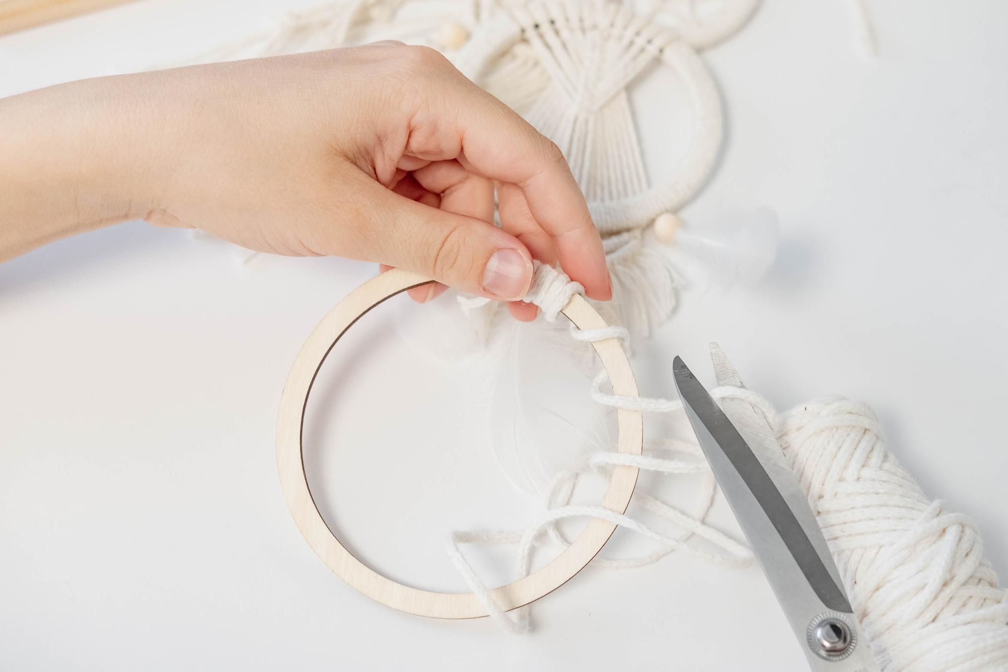 Hands working on embroidery sample with thread and hoop